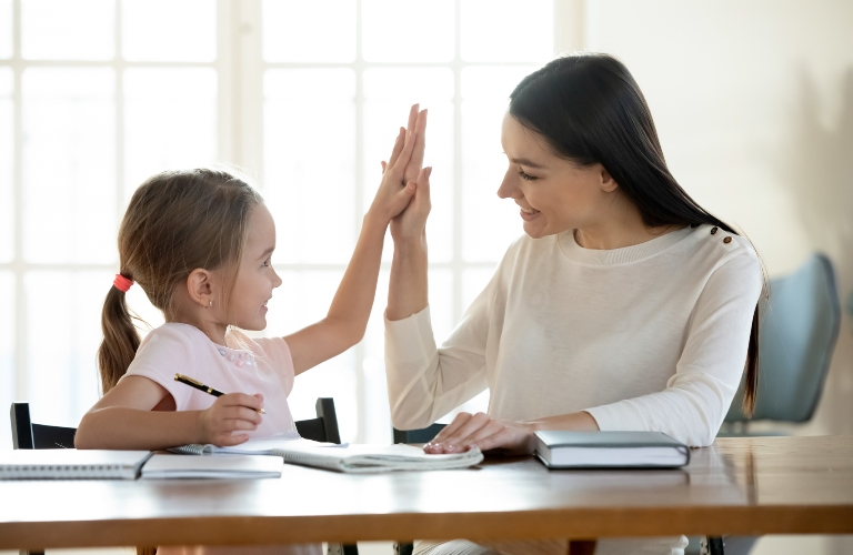 happy little daughter gives her mother a high five
