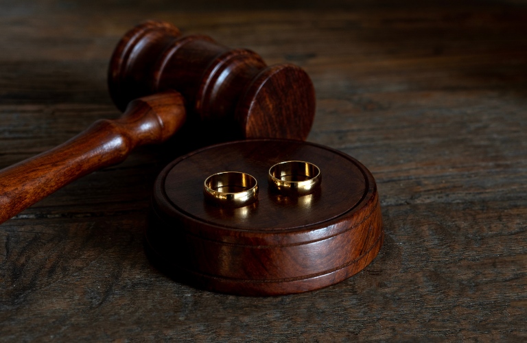 gavel and wedding rings on wooden table