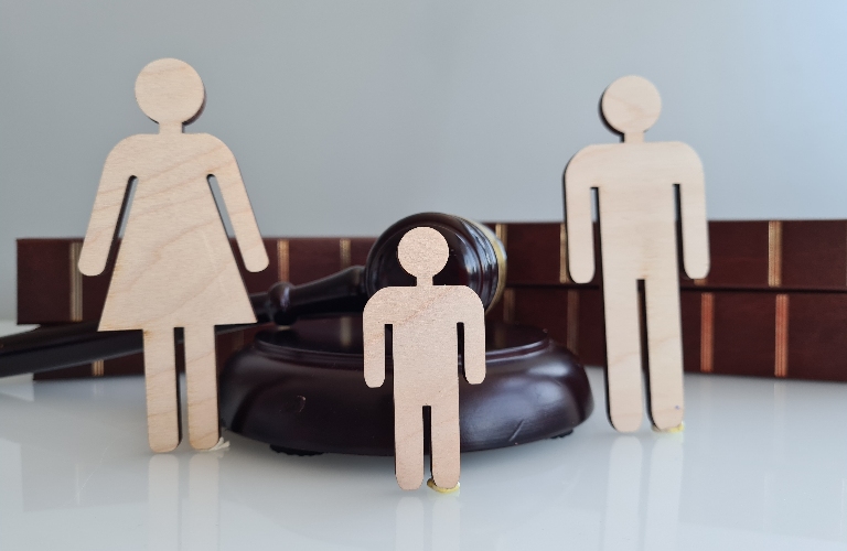 Wooden figures representing a family near a gavel