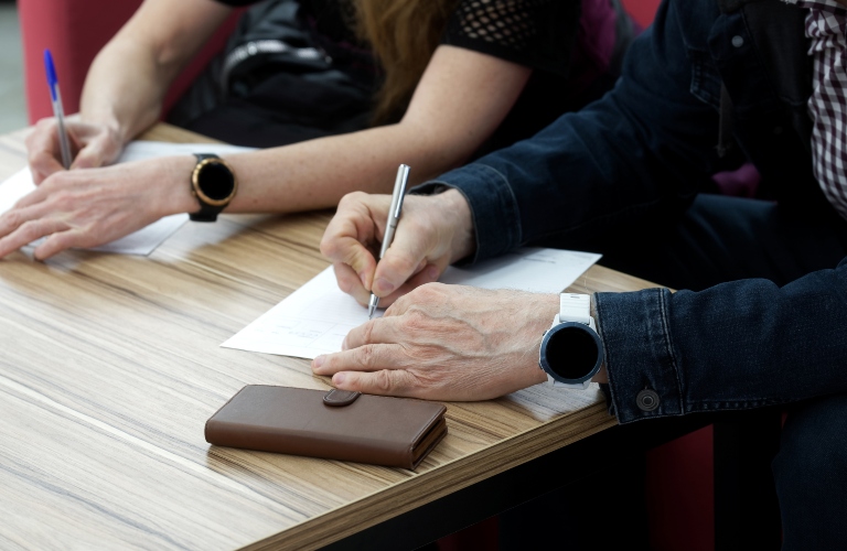 woman and man are signing documents